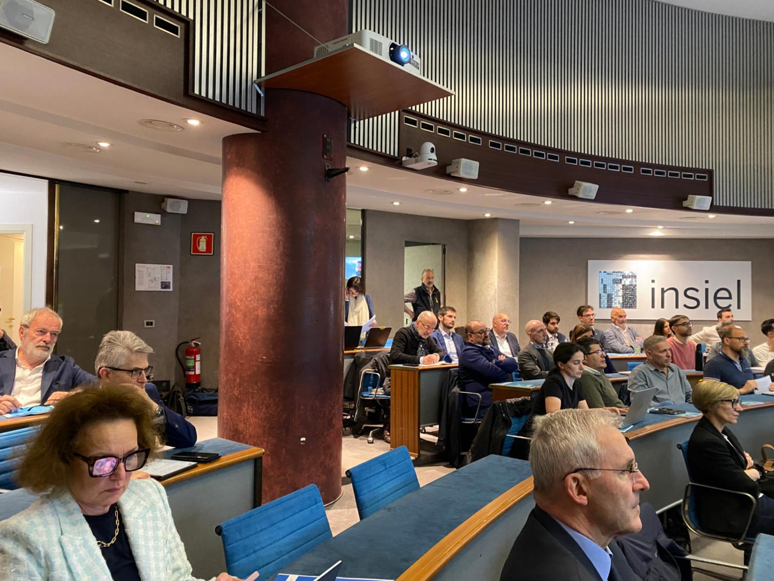 Il presidente Baritussio, a destra, e la platea che affollava l'auditorium Insiel a Trieste